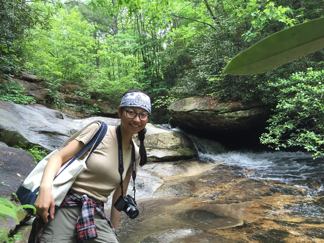 Image of Jianyu Wu standing in front of a stream. 