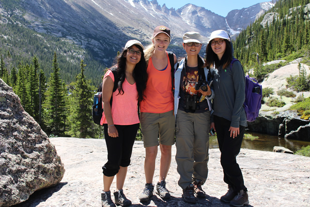 Image of four women standing in front of the mountain. 