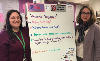 Image of two women standing at a white board. 