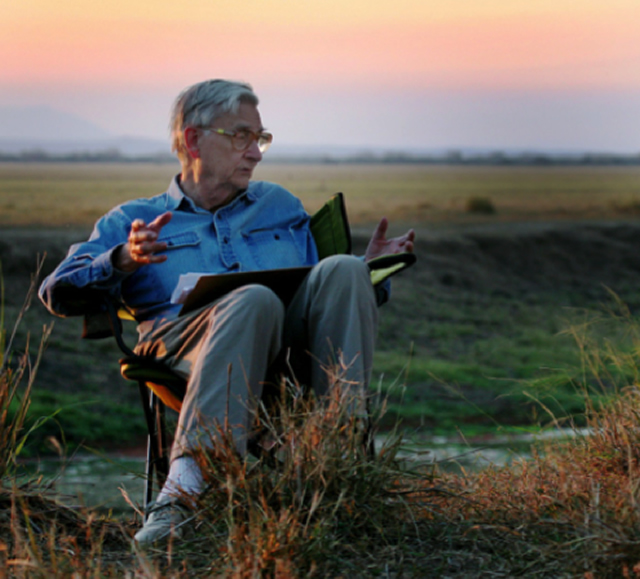 Image of E.O. Wilson sitting in a field. 