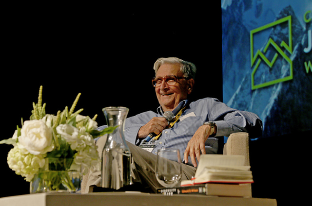 Image of E.O. Wilson on stage holding a microphone.