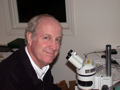 Man sitting at a microscope.