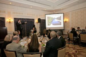 Image of people speaking onstage to a crowded room.