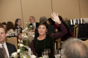 Image of a woman raising her hand.