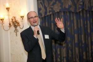 Image of a man speaking into a microphone.