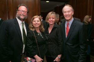 Image of four people smiling at the camera.