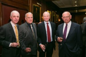 Image of four people smiling at the camera. 