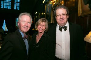 Image of three people smiling at the camera. 