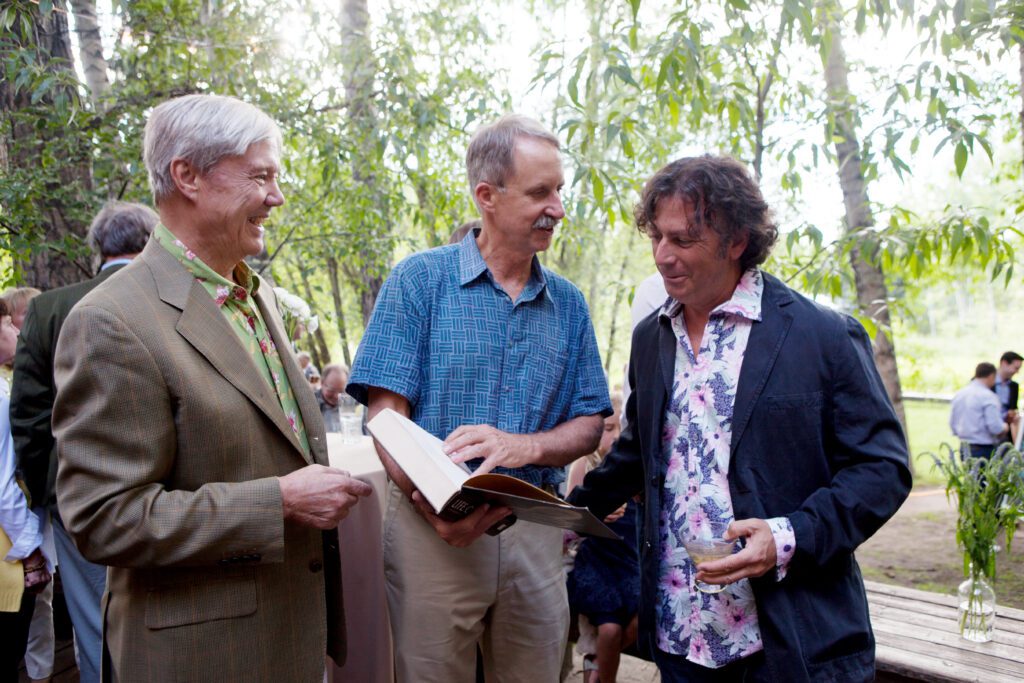 Image of three men looking at a book.