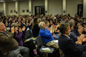 Image of a crowd of people clapping.