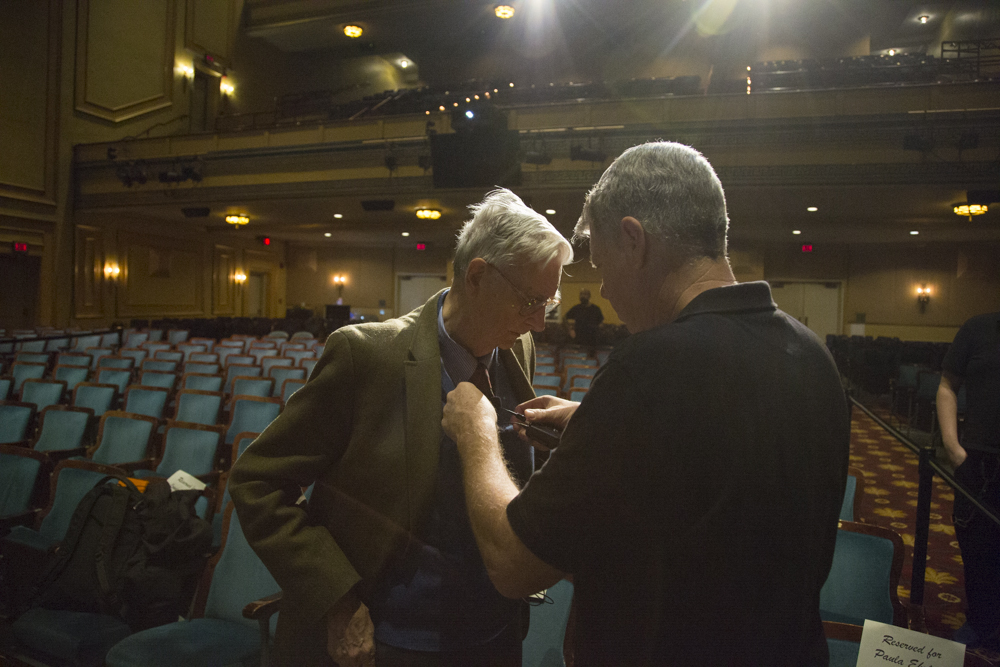 Image of E.O. Wilson getting a microphone put on him.