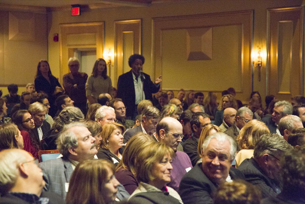 Image of people lined up to speak in a microphone.