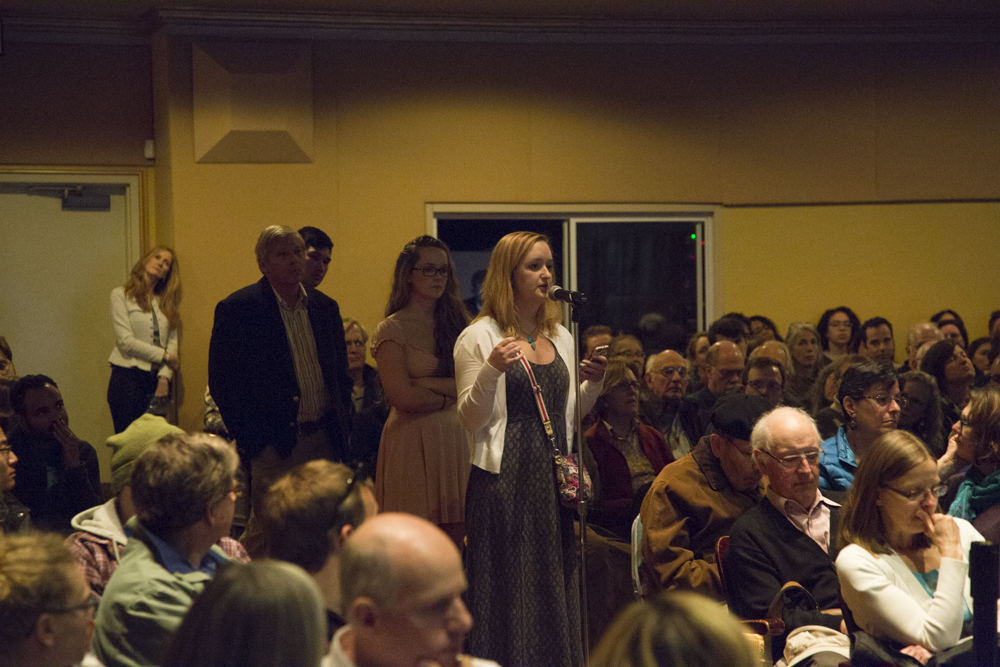 Image of people lined up to speak in a microphone.