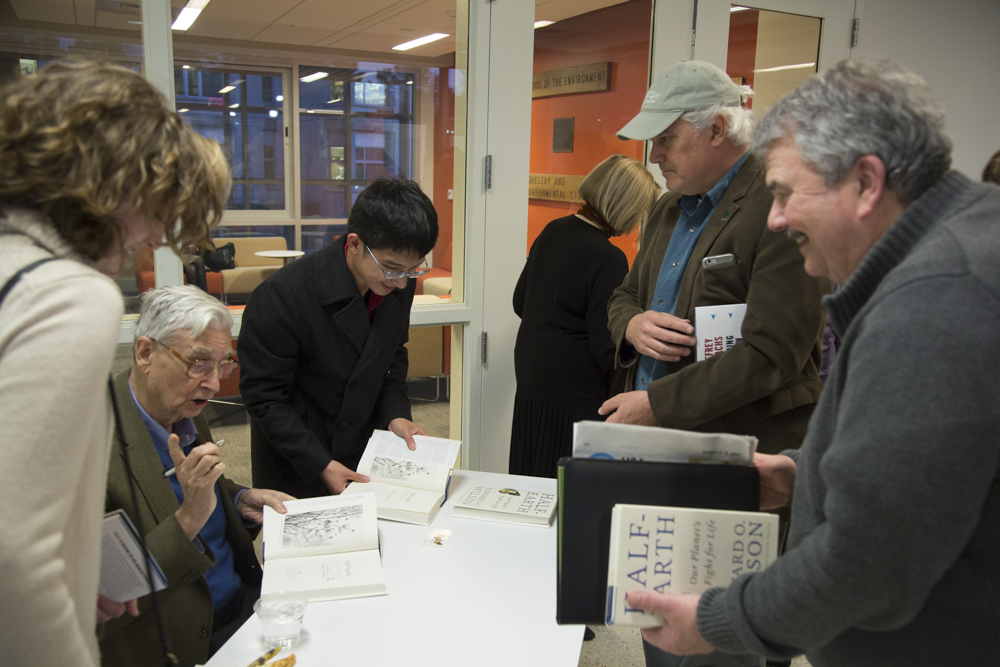 Image of E.O. Wilson signing books.