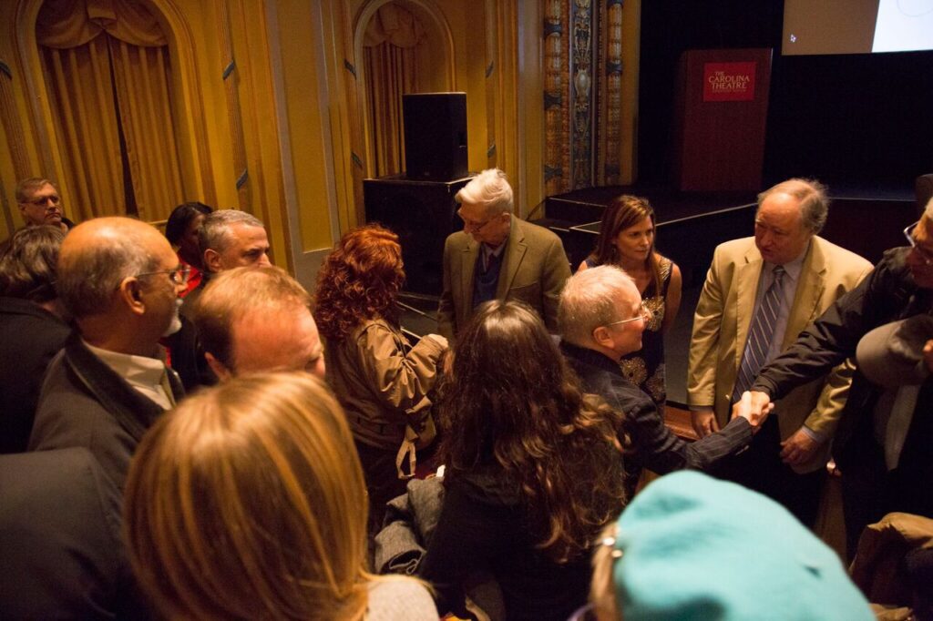 Image of a group of people speaking to E.O. Wilson.