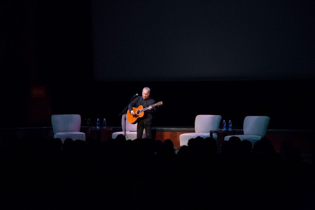 Image of Paul Simmons playing the guitar on stage.